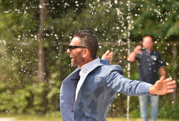 Drew Popish, northeast regional director for the Office of Governor Josh Shapiro, plays in the water at the Capouse Avenue Park splash pad in Scranton Thursday, August 13, 2026. (SEAN MCKEAG / STAFF PHOTOGRAPHER)