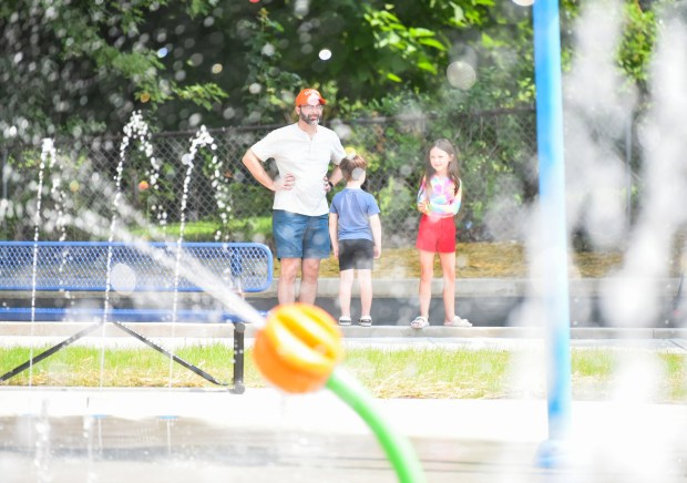 A family waits to use the Capouse Avenue Park splash pad in Scranton Thursday, August 13, 2026. (SEAN MCKEAG / STAFF PHOTOGRAPHER)