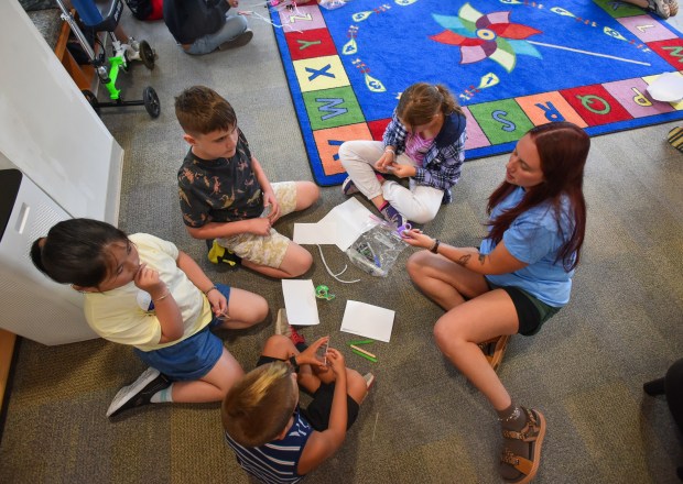 Engineer with Pennsylvania American Water Sarah Mihalick, right, instructs a group of students on how to build their own miniature water tanks during the Wonderful World of Water Camp at Valley Community Library in Peckville Monday, August 3, 2026. (SEAN MCKEAG / STAFF PHOTOGRAPHER)