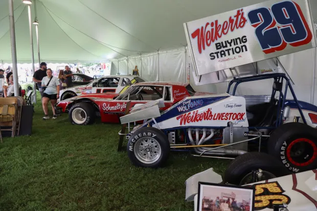 Racing cars are displayed under a tent Sunday, Aug. 2, 2026, at the 63rd annual Das Awkscht Fescht antique and classic car show at Macungie Memorial Park in Macungie. (Jon Chiu/The Morning Call)