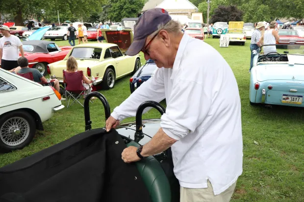 Donald Kaas of Bethlehem puts a tarp over the interior of his 2023 Morgan Super 3 on Sunday, Aug. 2, 2026, at the 63rd annual Das Awkscht Fescht antique and classic car show at Macungie Memorial Park in Macungie. (Jon Chiu/The Morning Call)