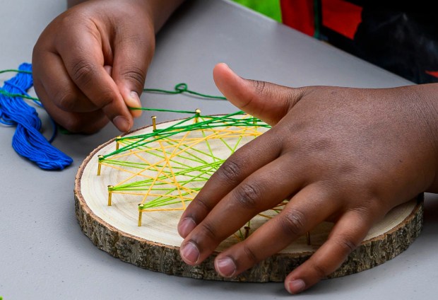 Dakota creates string art inspired by plants and flowers Monday, Aug. 17, 2026, during Art in the Garden: A Week of Creativity in Easton Urban Farm at the Neighborhood Center in Easton. During the event, children spend their mornings exploring the Easton Urban Farm while creating hands-on art inspired by the world around them.(April Gamiz/The Morning Call)