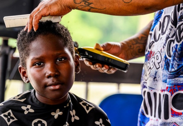Ryan receives a free hair cut by Los Rebolcones Jeep Club member Jose Colon on Saturday, Aug. 8, 2026, during the 9th Annual Back To School Event hosted by Puertorrican Culture Preservation Inc at Buck Boyle Park in Allentown. The event featured 500 free backpacks, snacks and back-to-school supplies given by local organizations. (April Gamiz/The Morning Call)