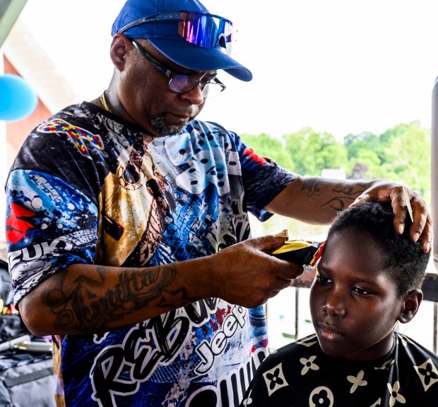 Ryan receives a free hair cut by Los Rebolcones Jeep Club member Jose Colon on Saturday, Aug. 8, 2026, during the 9th Annual Back To School Event hosted by Puertorrican Culture Preservation Inc at Buck Boyle Park in Allentown. The event featured 500 free backpacks, snacks and back-to-school supplies given by local organizations. (April Gamiz/The Morning Call)