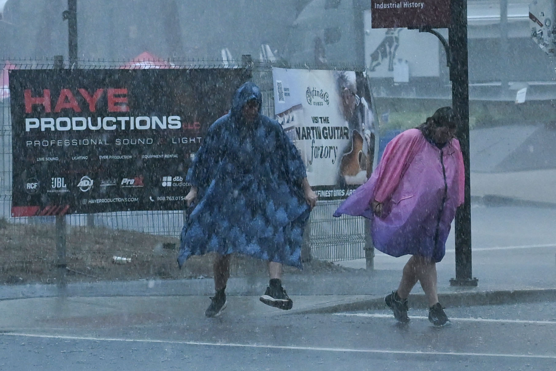 People in rain ponchos run for shelter from a storm during Musikfest on Friday, Aug. 7, 2026, at the SteelStacks in Bethlehem. (Jon Chiu/The Morning Call)