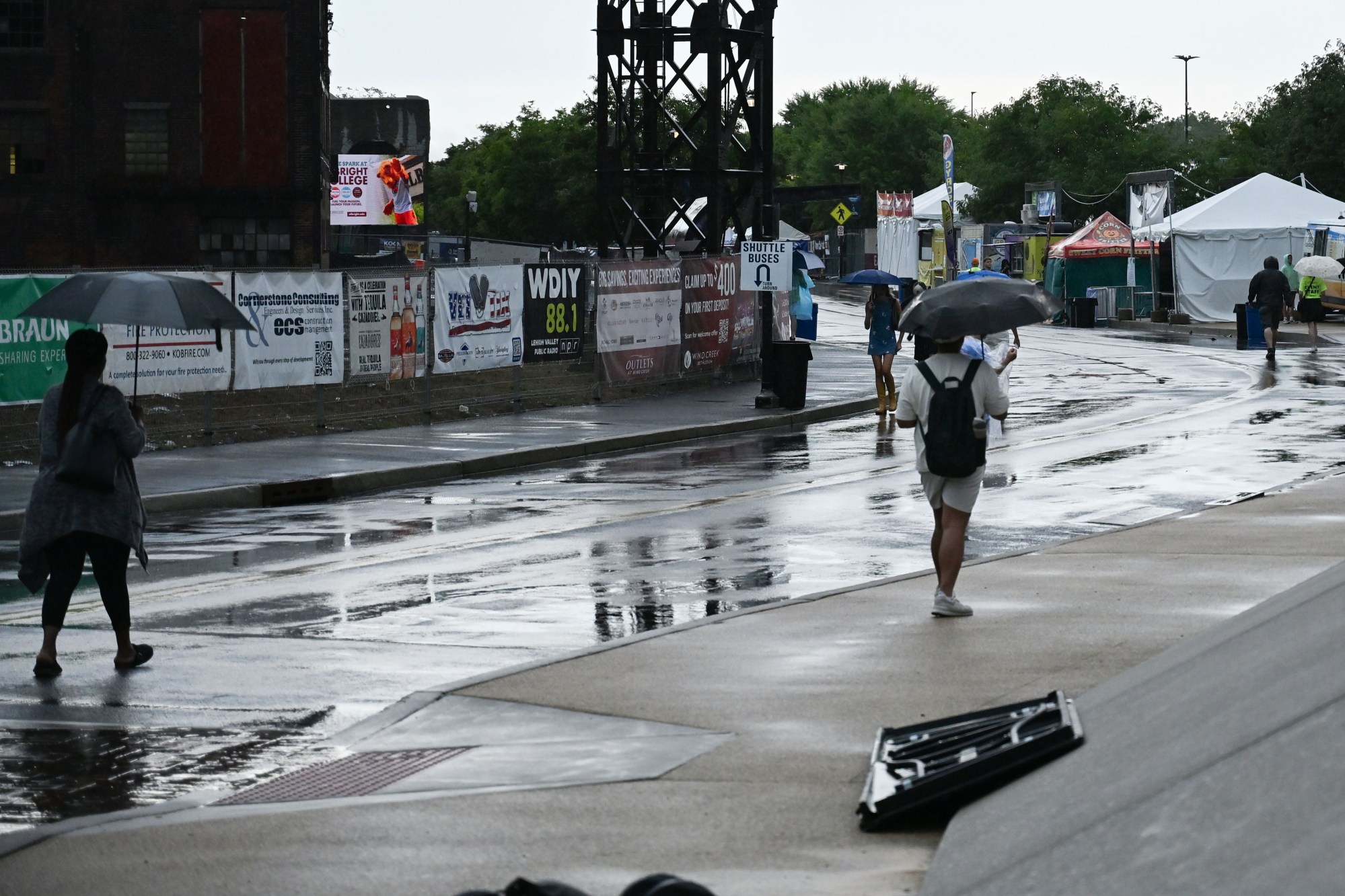 People walk around Musikfest following its temporary shutdown by a passing storm on Friday, Aug. 7, 2026, at the SteelStacks in Bethlehem. (Jon Chiu/The Morning Call)