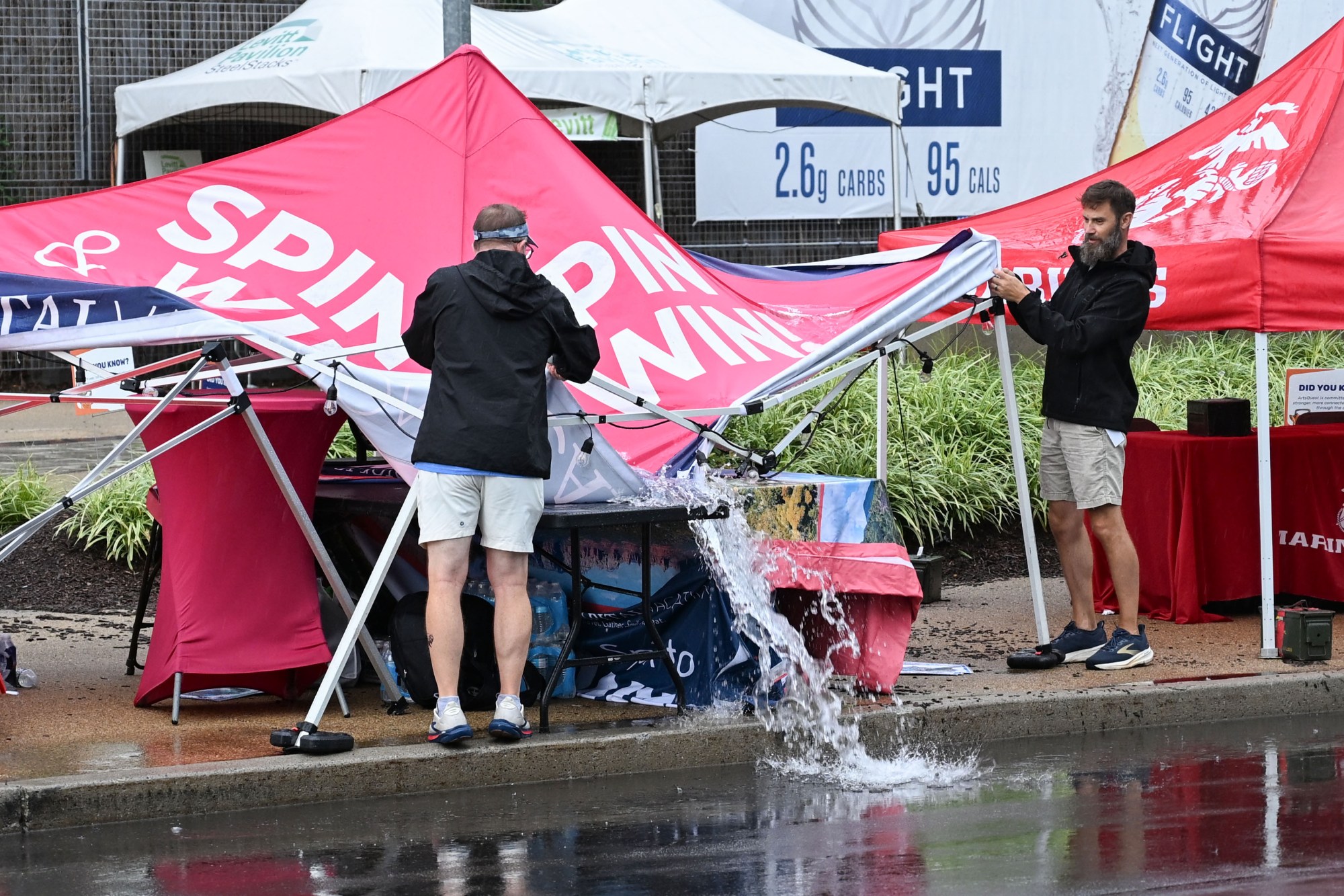 People drain tents of rainwater following a storm during Musikfest on Friday, Aug. 7, 2026, at the SteelStacks in Bethlehem. (Jon Chiu/The Morning Call)