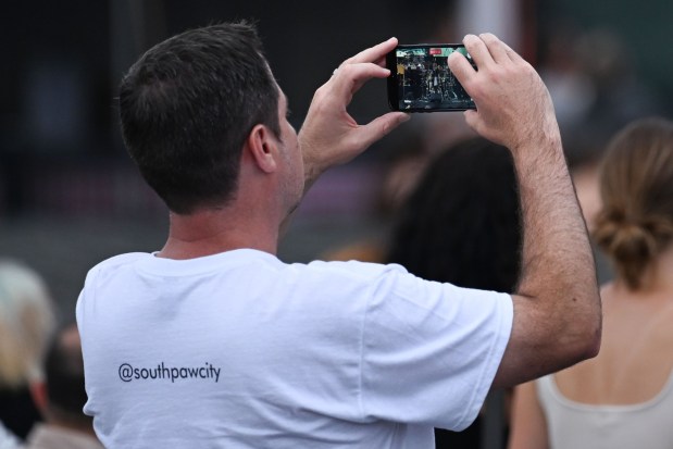 A festival goer records the country music trio Southpaw open for Parker McCollum during Musikfest on Friday, Aug. 7, 2026, on the Wind Creek Steel Stage at PNC Plaza in Bethlehem. (Jon Chiu/The Morning Call)