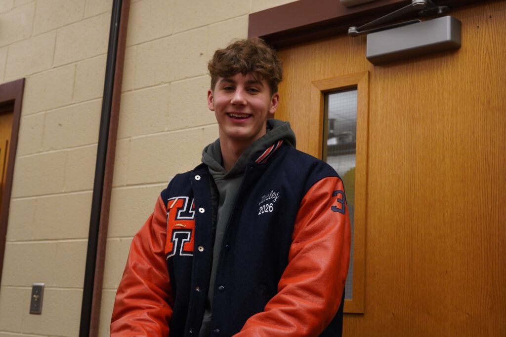 Caleb Michael Tinsley is standing in a hallway in the school posing for a photo.