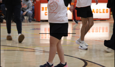 student with arms up in the air in celebration