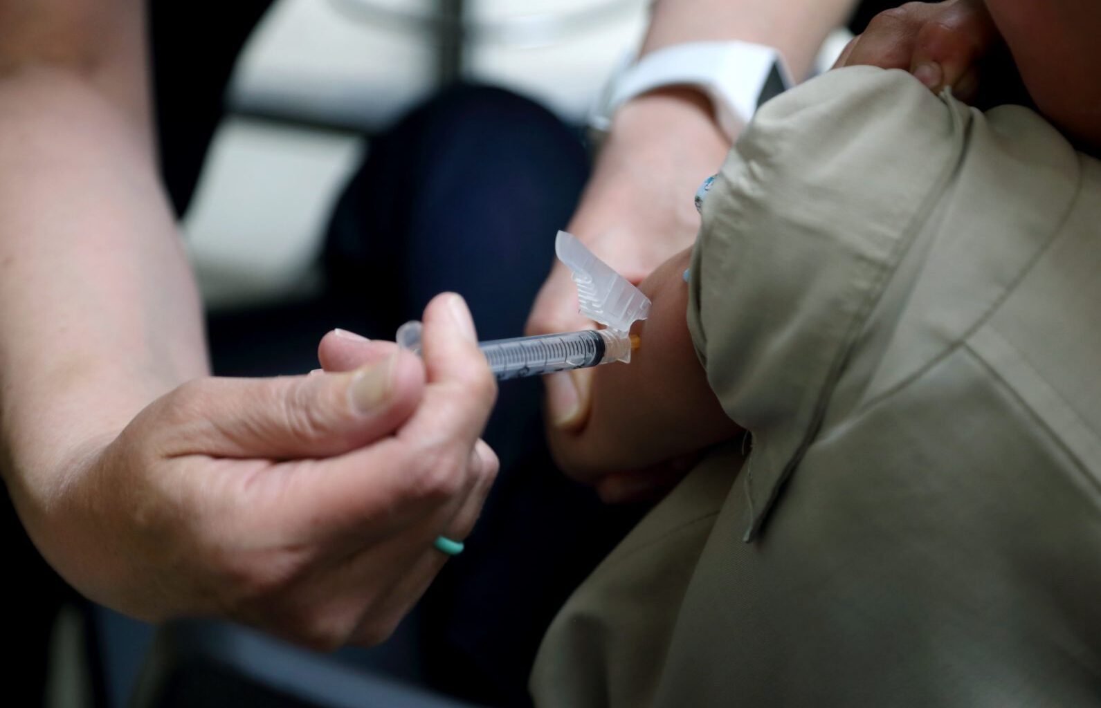 FILE PHOTO: Starr Roden, left, a registered nurse and immunization outreach coordinator with the Knox County Health Department, administers a vaccination to Jonathan Detweiler, 6, at the facility in Mount Vernon, Ohio.