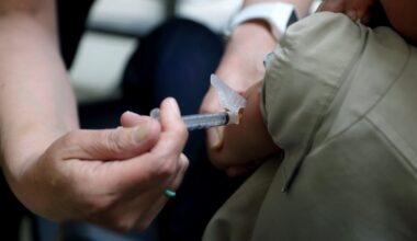 FILE PHOTO: Starr Roden, left, a registered nurse and immunization outreach coordinator with the Knox County Health Department, administers a vaccination to Jonathan Detweiler, 6, at the facility in Mount Vernon, Ohio.