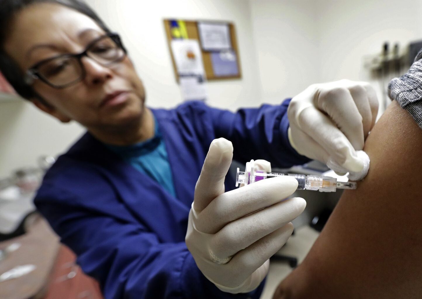 FILE PHOTO: Ana Martinez, a medical assistant at the Sea Mar Community Health Center, gives a patient a flu shot, Thursday, Jan. 11, 2018 in Seattle.