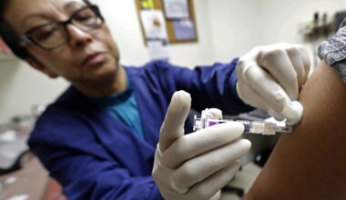FILE PHOTO: Ana Martinez, a medical assistant at the Sea Mar Community Health Center, gives a patient a flu shot, Thursday, Jan. 11, 2018 in Seattle.
