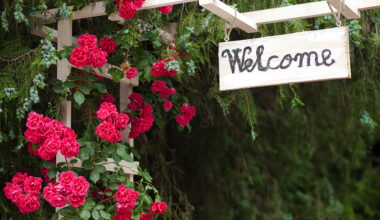 Red,flowers,and,welcome,wood,panel,at,hotel,entrance