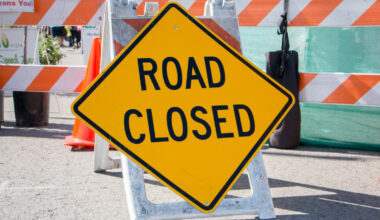 Road Closed Sign with Barricade in Background