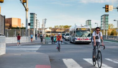 Cyclists are shown commuting on city streets with cars and traffic in University City.