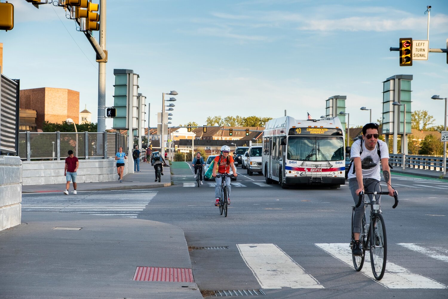 Cyclists are shown commuting on city streets with cars and traffic in University City.