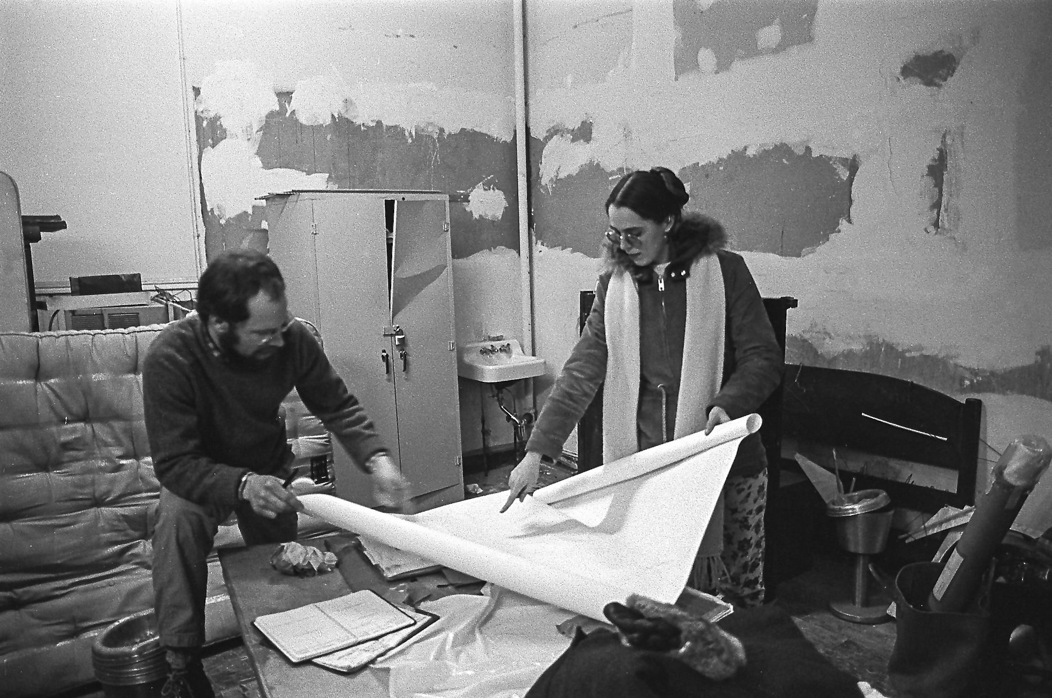 Virginia Maksymowicz and Richard Nicksic unrolling a scroll or canvas
