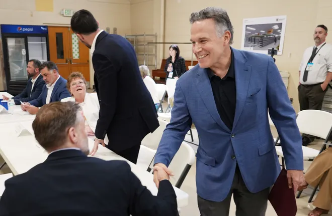 U.S. Senator Dave McCormick, right, greets community leaders prior to a roundtable discussion dealing with housing, food insecurity and homelessness held at St. Paul's Neighborhood Center in Erie, Pa., on Aug. 28, 2026. U.S. Senator John Fetterman also attended.
