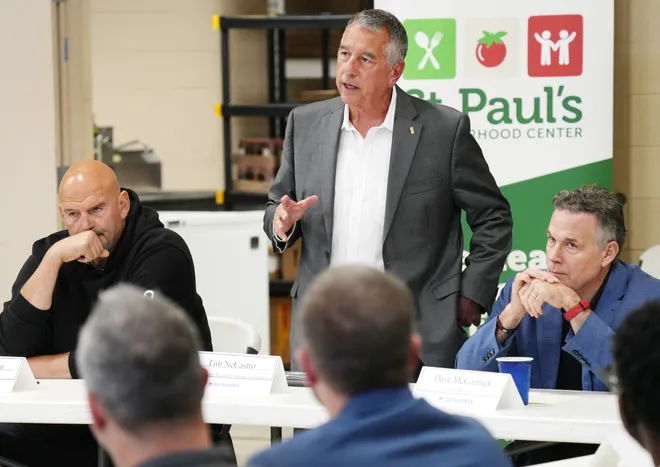 U.S. Senators John Fetterman, left, and Dave McCormick, right, flank Erie Insurance CEO Tim NeCastro as he opens a roundtable discussion with community leaders dealing with housing, food insecurity and homelessness in Erie, Pa., on Aug. 28, 2026.