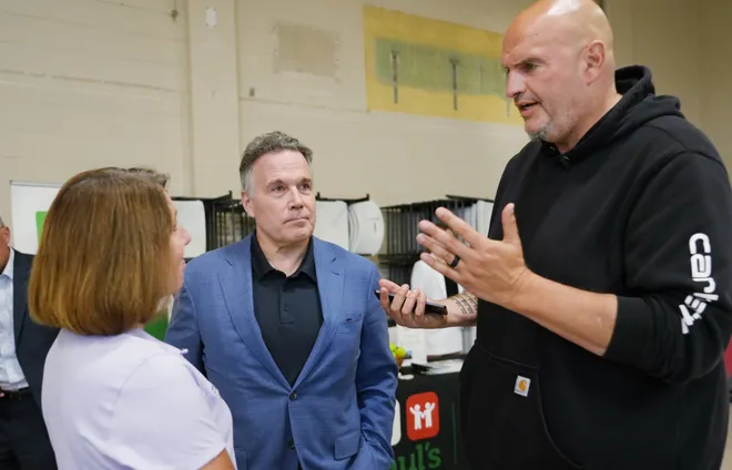 City of Erie Mayor Daria Devlin, left, talks with Pennsylvania's U.S. Senators Dave McCormick, left, and John Fetterman after a roundtable discussion with community leaders dealing with housing, food insecurity and homelessness in Erie, Pa., on Aug. 28, 2026.