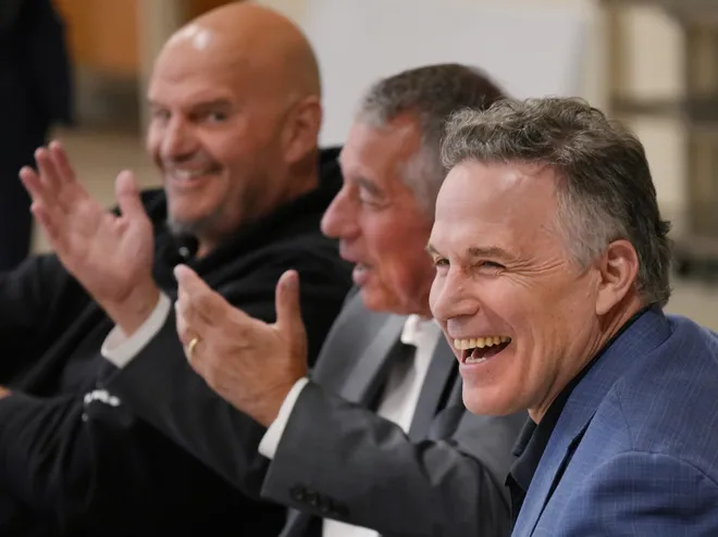 Pennsylvania's U.S. Senators John Fetterman, left, and Dave McCormick, right, laugh at a joke from Erie Insurance CEO Tim NeCastro during a roundtable discussion with community leaders dealing with housing, food insecurity and homelessness held at St. Paul's Neighborhood Center in Erie, Pa., on Aug. 28, 2026.