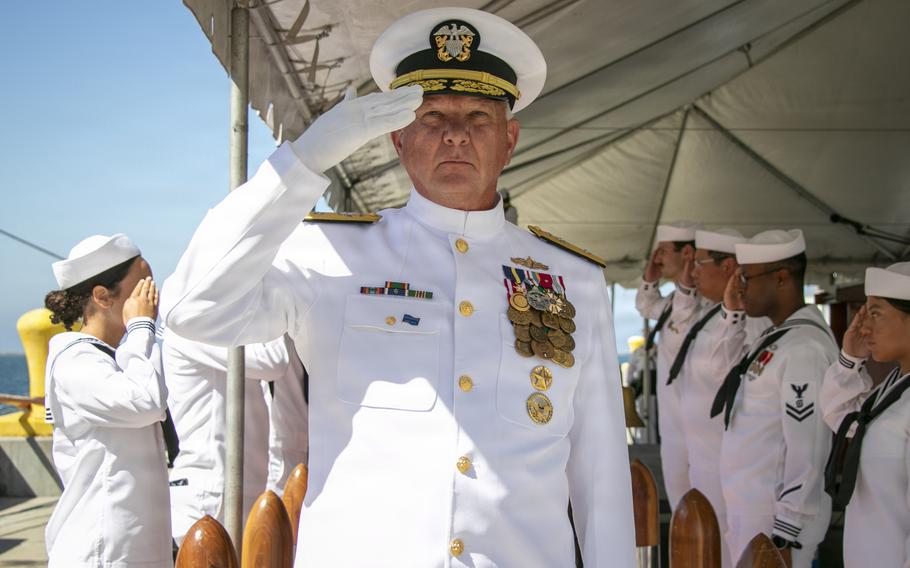 A sailor holds a salute.