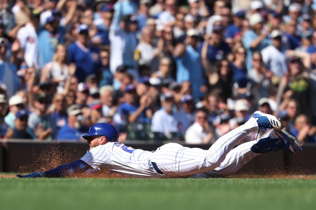 Cubs first baseman Michael Busch slides safely into third base after advancing on a Pirates error hitting a double in the third inning Friday, Sept. 11, 2026, at Wrigley Field. (Chris Sweda/Chicago Tribune)