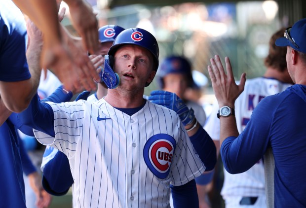Cubs center fielder Pete Crow-Armstrong high-fives teammates in the dugout after scoring on a Michael Busch sacrifice fly in the fourth inning against the Pirates on Sept. 11, 2026, at Wrigley Field. (Chris Sweda/Chicago Tribune)
