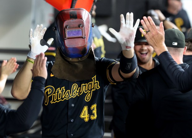 Pittsburgh Pirates catcher Rafael Flores Jr. (43), wearing a mask, is congratulated by his teammates in the dugout after hitting a solo home run in the fifth inning of a game against the Chicago White Sox at Rate Field in Chicago on Sept. 8, 2026. (Chris Sweda/Chicago Tribune)