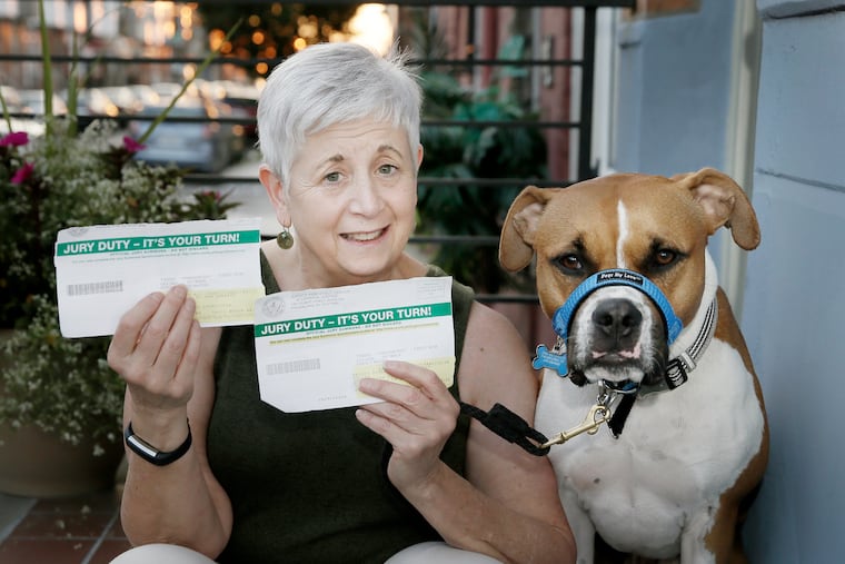 Carol Brodie-Mackin sits with her dog Junior, and the two jury duty notices she received in May 2018.