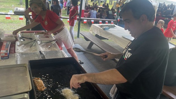 Elena Timko and Pete Keselicka ready and order of fried dough at the Hazleton UNICO's Fabulous Fried Dough during the UNICO's 17th annual Bell' Italia Festival Friday Sept. 5, 2025 at Community Park in Hazle Township. (John Haeger / Staff Photographer)