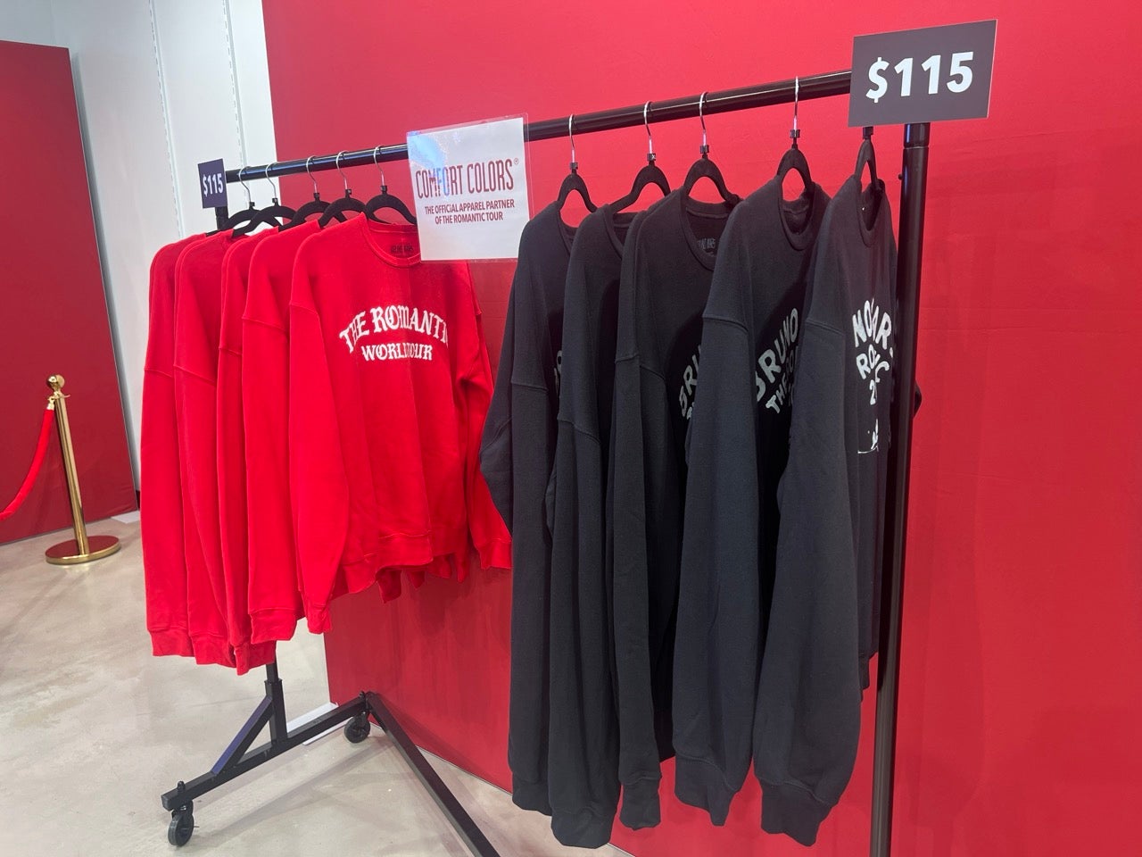 Red and black shirts hung on a clothing rack in the Bruno Mars and Hello Kitty pop-up merch shop in Philly.