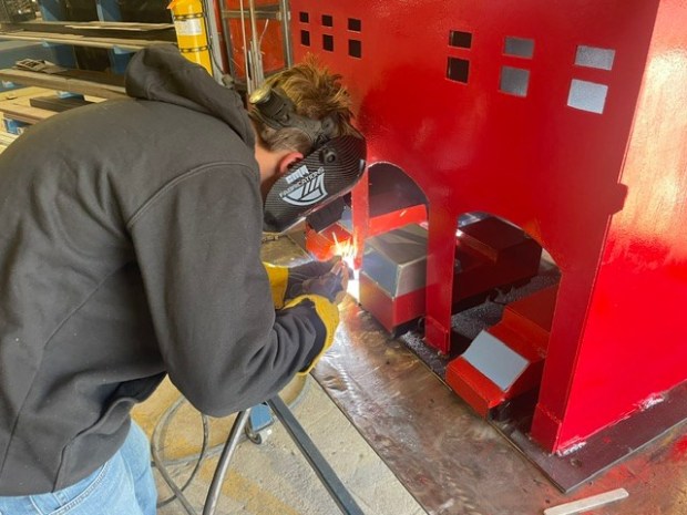 North Montco Technical Career Center junior Matt Tomczak welds a fire station and firetrucks meant to be added to the school's September 11 memorial garden. (Photo courtesy of North Montco Technical Career Center)