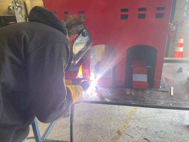 North Montco Technical Career Center junior Matt Tomczak welds a fire station and firetrucks meant to be added to the school's September 11 memorial garden. (Photo courtesy of North Montco Technical Career Center)