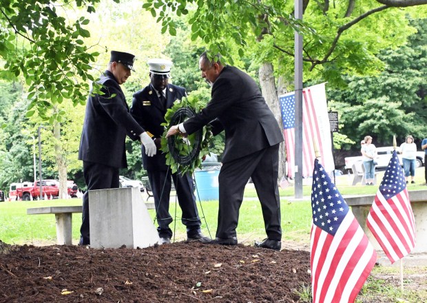 From left, Reading Firefighter Union Local 1803 president Micahel Shoumliksy, Reading Fire Chief Robert Leonard II and Mayor Eddie Moran place a wreath at the Sept. 11 tree during the city's commemoration of the 25th Anniversary of Sept. 11, 2001, on Friday in City Park.   (BILL UHRICH/READING EAGLE)