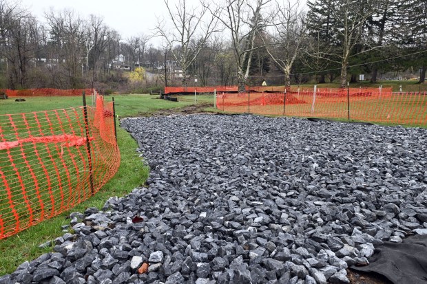 A temporary access road to the Egelman Park pond is under construction. Fill will be trucked in to raise the bed of the pond, producing less water pressure against the dam. (BILL UHRICH/READING EAGLE)