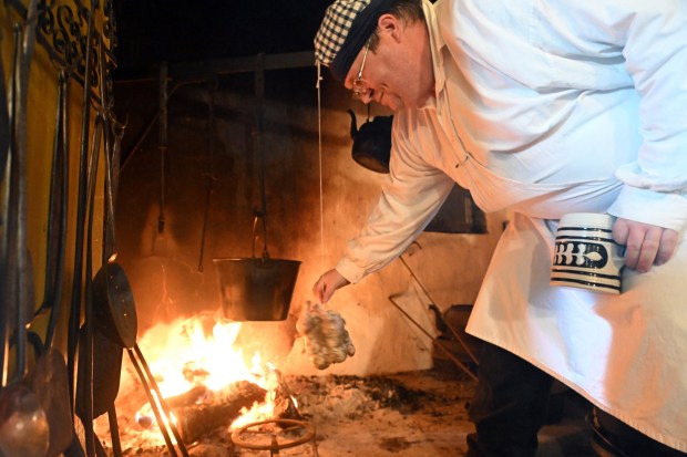 Daniel Silfies of Lancaster roasts a chicken in the fireplace at the Eichler-Frankenfield Home during the Heemet Fescht at the Pennsylvania German Cultural Heritage Center at Kutztown University on Saturday, Sept. 26, 2026. (BILL UHRICH/READING EAGLE)