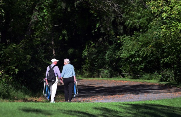 A couple walks with their lawn chairs to the Ringgold Band concert Monday by the Red Bridge at the Berks County Heritage Center for the annual Labor Day concert. (BILL UHRICH/READING EAGLE)