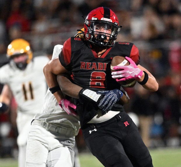 Reading High's Nasiah Molena catches a pass and is wrapped up against Muhlenberg at Shirk Stadium on Thursday, Sept. 3, 2026. (BILL UHRICH/READING EAGLE)