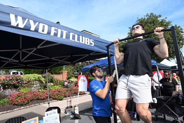 Jaden Duron, left, spots while Nick Lloyd does pull-ups at the Wyomissing Fitness and Training Center tent during the West Reading Fall Festival on Saturday, Sept. 19, 2026. . (BILL UHRICH/READING EAGLE)