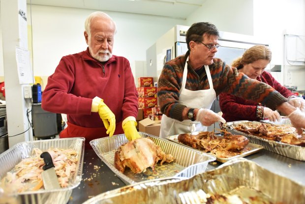 Organizer Bob Bolus and volunteer Bob Irving cut turkey in the kitchen of All Saints Academy in Scranton Christmas Day Monday, December 25, 2023.