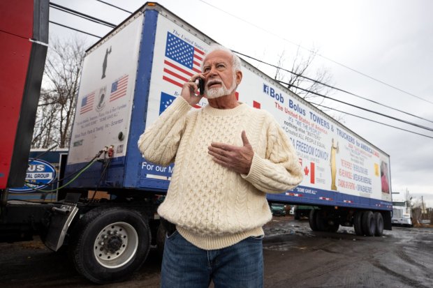Bob Bolus talks on his phone outside his business in Throop before driving his truck on a "Save America Freedom Convoy" from Scranton to Washington, D.C.