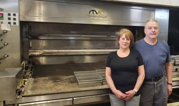 Kathy and Robert Lucci shown at Lucci's Bakery in Archbald on Saturday Aug. 22, 2026. The couple recently announced they would be closing the bakery. Shown in the background is a Benini oven from Verona, Italy. Lucci travelled there to facilitate the purchase in 1980. (GERI GIBBONS/STAFF PHOTO)
