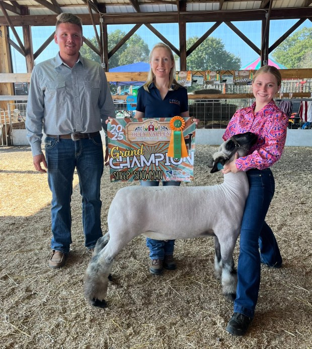 Danica Rhoads holds her grand champion sheep. With her are Jeremy Rose, judge, and Lynette Gelsinger of banner sponsor First Citizens Community Bank. (Courtesy of the Oley Valley Community Fair)