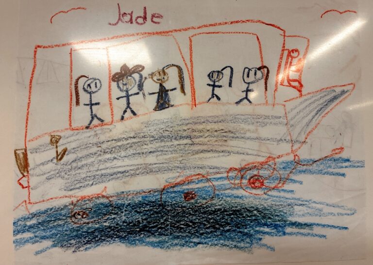 Child’s drawing of five stick figures standing on a boat in blue water, with two red birds in the sky and the name “Jade” written at the top in red crayon.