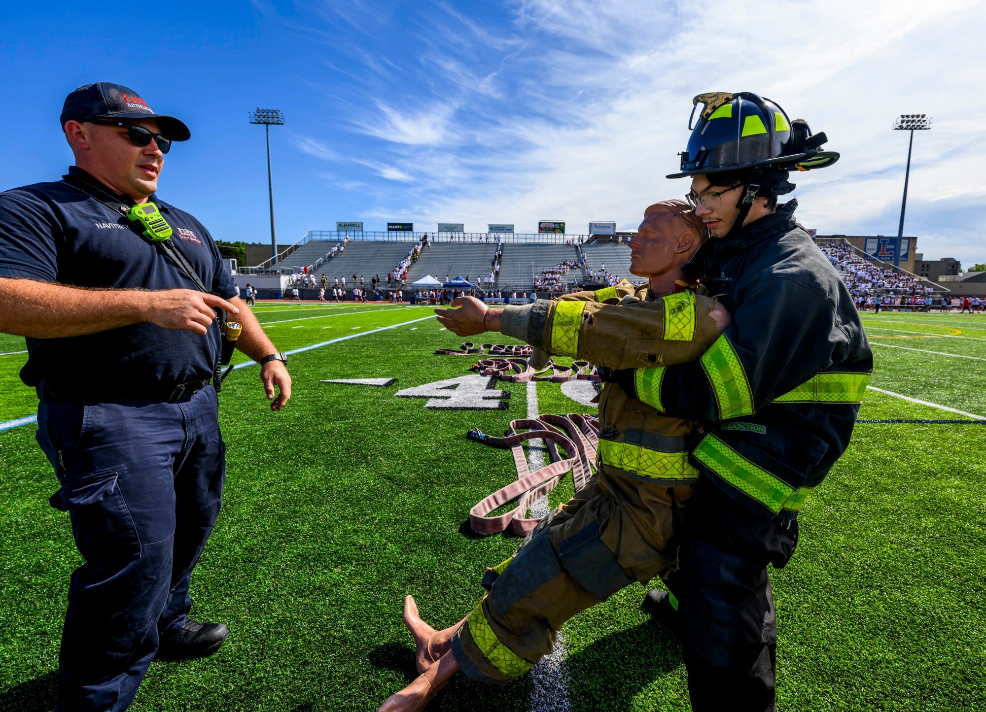 Liberty student Anthony Vargas tries out a rescue dummy drill with the help of Bethlehem firefighter Tim Navitsky on Friday, Sept. 11, 2026, during "The Climb" event at BASD Stadium in Bethlehem. Bethlehem Area high school students, staff, first responders, military personnel and community partners came together for a student-centered 9/11 remembrance event in which students from Freedom and Liberty High Schools climbed the stadium steps, walked the track and engaged in other activities to remember the lives lost 25 years ago. The goal was to climb 2,200 stairs or walk three miles, symbolizing 110 flights of stairs in one of the World Trade Center towers. (April Gamiz/The Morning Call)
