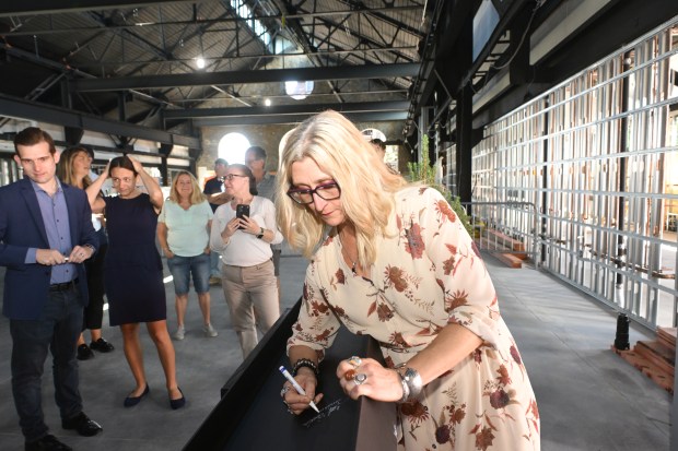 Northampton County Executive Tara Zrinski signs a beam Friday, Sept. 18, 2026, that will ultimately become part of the revitalized building as ArtsQuest celebrates its construction milestone for the Lehigh Valley Health Network, part of Jefferson Health Turn & Grind Shop at SteelStacks. (Monica Cabrera/The Morning Call)