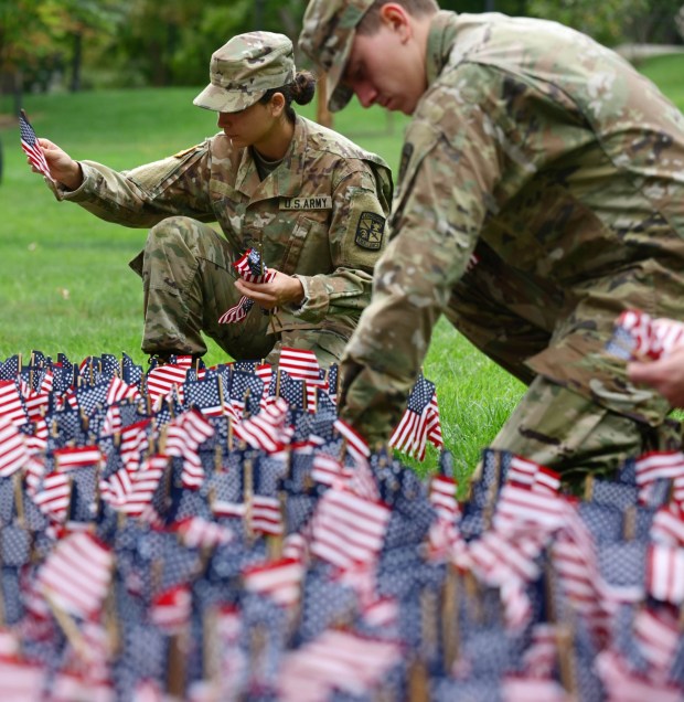 Kitira Bravo, places miniature American flags into the ground as Lehigh University and the Steel Battalion Army ROTC Program hold their annual 9/11 memorial event Friday, Sept. 11, 2026, in Bethlehem, to mark the 25th anniversary of the terror attacks. The ceremony included a flag raising, moment of silence and the planting of the 2,977 American flags to honor the lives lost. (Monica Cabrera/The Morning Call)
